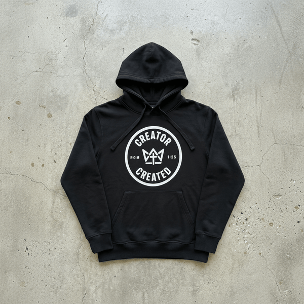 Black Foundation Hoodie with minimalist logo on concrete surface