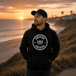 Black Foundation Hoodie with minimalist logo on concrete surface